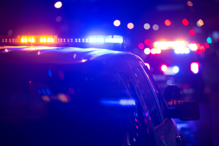 A police car at night time with flashing lights.