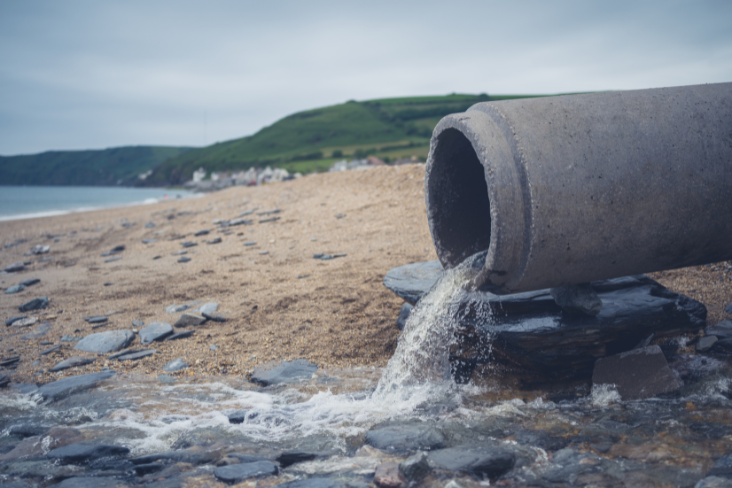 Pipe emptying water onto a beach