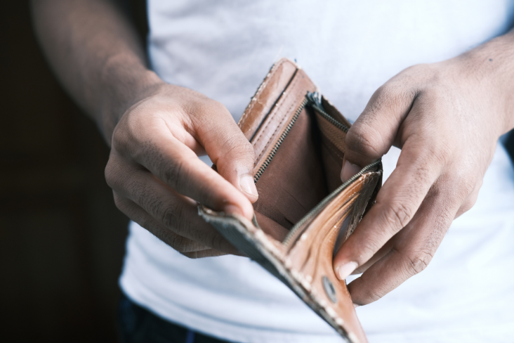 A man holding an empty leather wallet A man holding an empty leather wallet