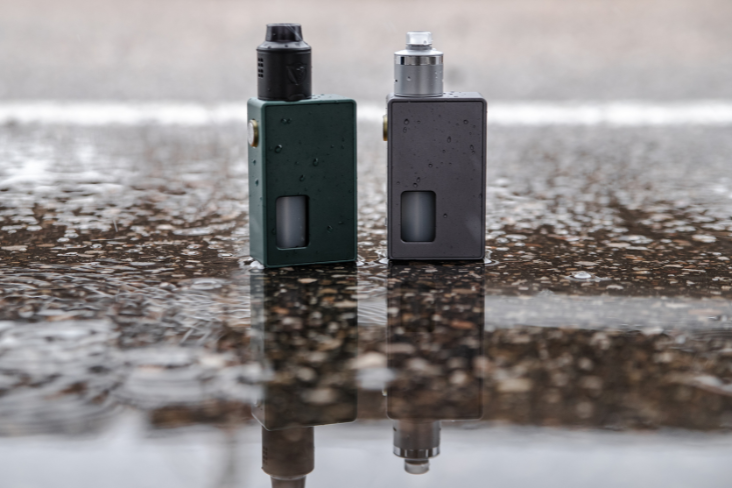 Two vapes on wet concrete